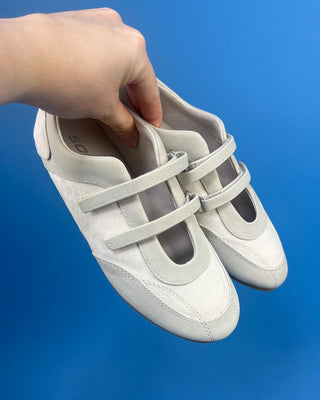 Ivory Faux Suede Mary Jane Double Strap Flat held up against a solid blue background. 