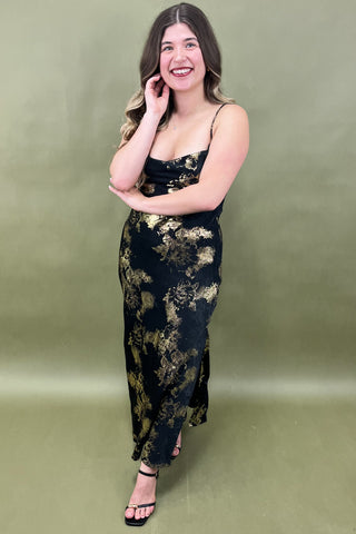 Woman wearing a black floral dress against a green background