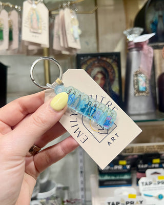 Many Mary Keychain held up in a store setting