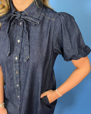 a dark indigo denim short-sleeve button-down shirt dress with a tie-neck detail