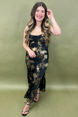 Woman wearing a black floral dress against a green background