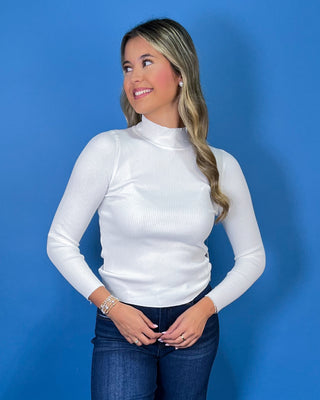 White ribbed mock neck top featuring long sleeves, a fitted silhouette, soft stretch texture, and a clean, classic look.