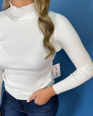 White ribbed mock neck top featuring long sleeves, a fitted silhouette, soft stretch texture, and a clean, classic look.