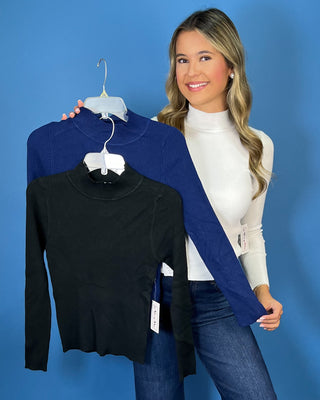 White ribbed mock neck top featuring long sleeves, a fitted silhouette, soft stretch texture, and a clean, classic look.