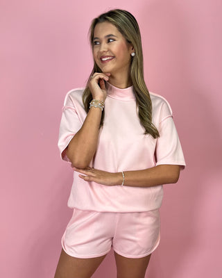 Woman wearing a pink outfit against a pink background