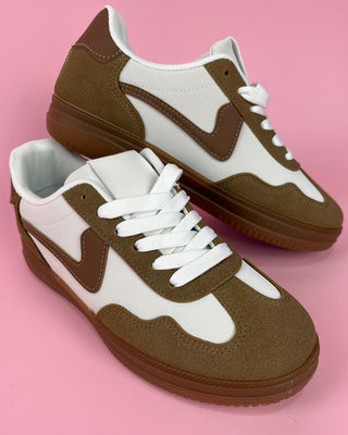 Brown and white sneakers on a pink background