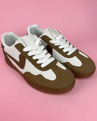 Brown and white sneakers on a pink background