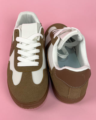 Brown and white sneakers on a pink background