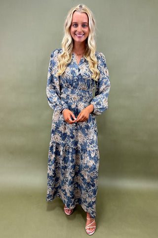 Woman wearing a blue floral dress against a green background
