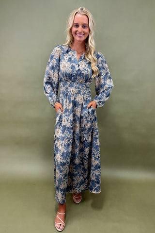 Woman wearing a blue floral dress against a green background