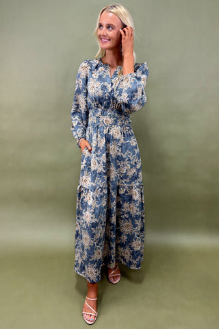 Woman wearing a blue floral dress against a green background
