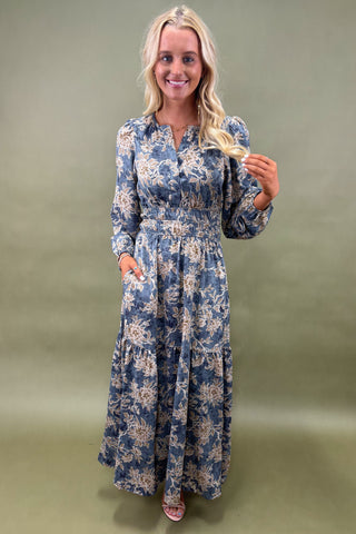 Woman wearing a blue floral dress against a green background