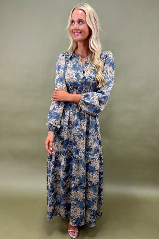 Woman wearing a blue floral dress against a green background