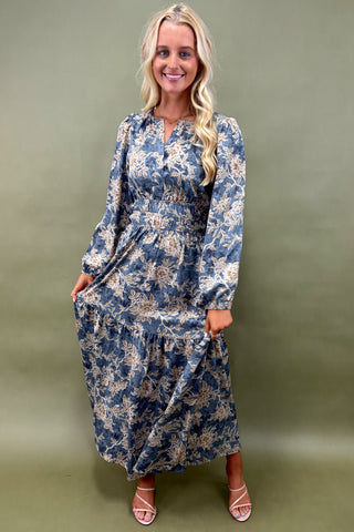Woman wearing a blue floral dress against a green background