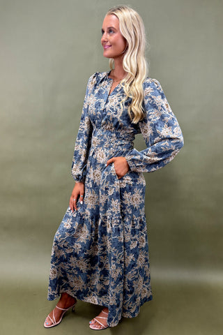 Woman wearing a blue floral dress against a green background