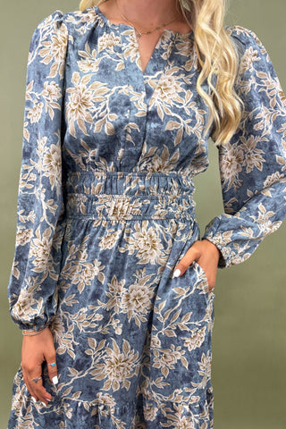Woman wearing a blue floral dress against a green background