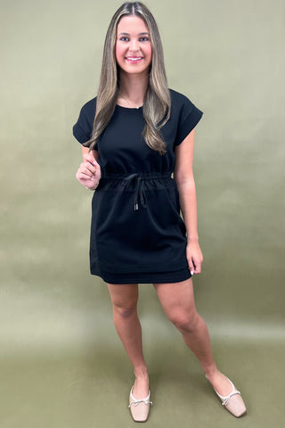 Woman wearing a black dress against a green background