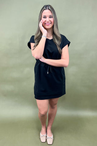 Woman wearing a black dress against a green background