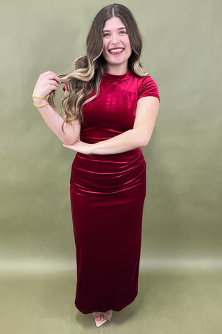 Woman wearing a red dress against a green background