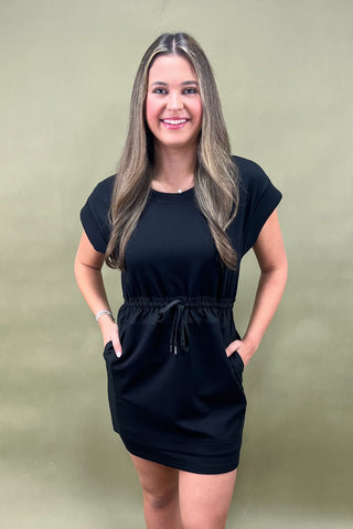 Woman wearing a black dress against a green background