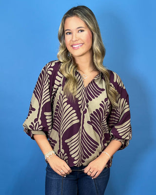 Plum and taupe leaf print blouse with a V-neckline, relaxed fit, and voluminous three-quarter sleeves.