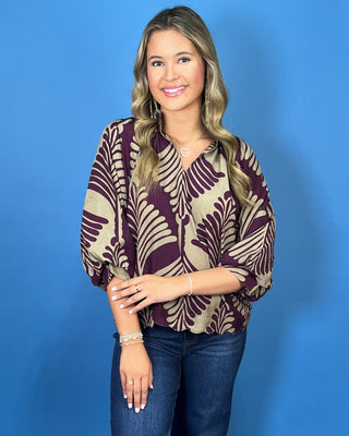 Plum and taupe leaf print blouse with a V-neckline, relaxed fit, and voluminous three-quarter sleeves.