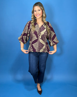 Plum and taupe leaf print blouse with a V-neckline, relaxed fit, and voluminous three-quarter sleeves.