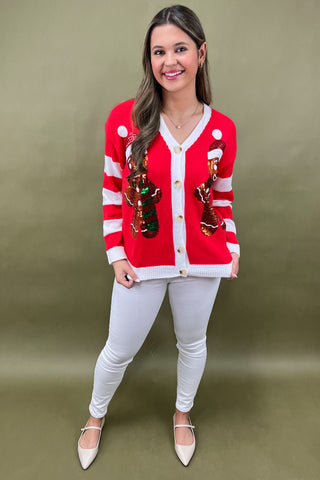 Woman wearing a red and white striped cardigan with decorative buttons on a green background