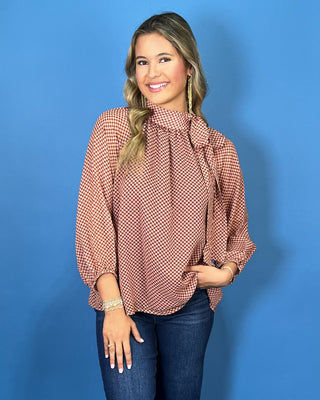 Mocha and blush dot print blouse with a high tie neckline, long sleeves, and a relaxed flowy fit.