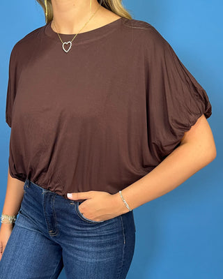 Chocolate brown dolman sleeve top with a relaxed fit, crew neckline, and gathered hem.