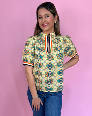Woman wearing a patterned shirt with a pink background