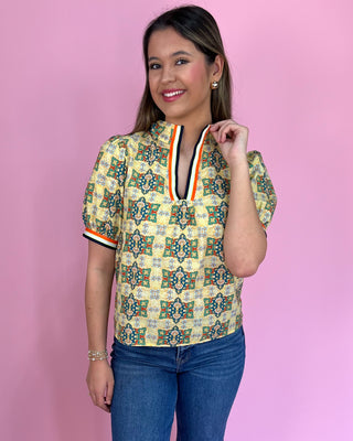 Woman wearing a patterned shirt with a pink background