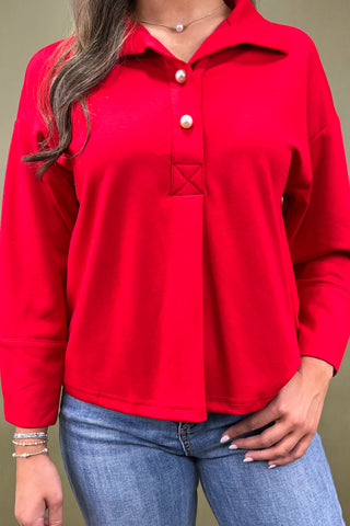 Red long-sleeve shirt worn by a person on a plain background
