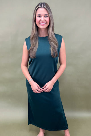 Woman wearing a teal dress against a beige background
