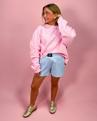 Woman wearing a colorful sweater with a pink background