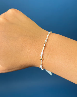 Enewton Hope Unwritten Daydreaming Bracelet displayed on a wrist on a solid blue background. 