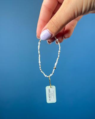 Enewton Hope Unwritten Daydreaming Bracelet displayed on a wrist on a solid blue background. 