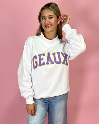 Person wearing a white sweatshirt with 'GEaux' text on a pink background