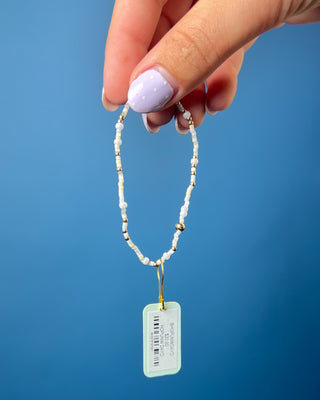 Enewton Hope Unwritten Daydreaming Bracelet displayed on a wrist on a solid blue background. 