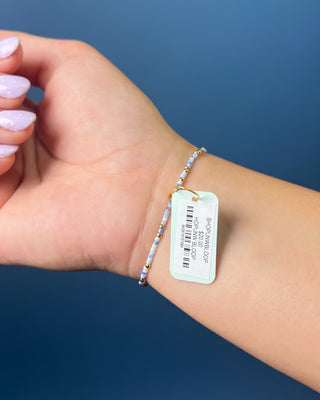 Enewton Hope Unwritten Bloopers Blue White and Gold Bracelet displayed on a solid blue background. 