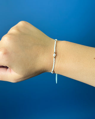 Enewton Hope Purpose Pearl Milkshake Bracelet against a solid blue background. 