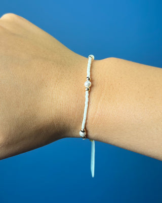 Enewton Hope Purpose Pearl Milkshake Bracelet against a solid blue background. 