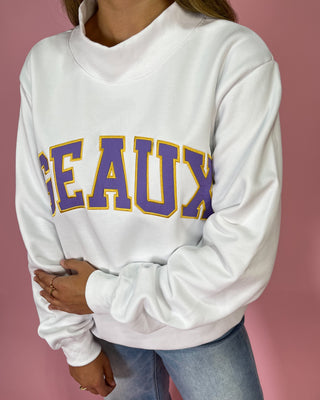 White sweatshirt with 'GEAUX' printed in purple and yellow on a pink background