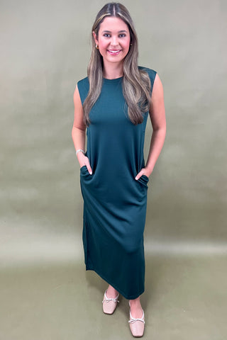 Woman wearing a green dress against a plain background
