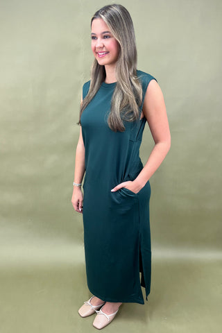 Woman wearing a green dress against a beige background