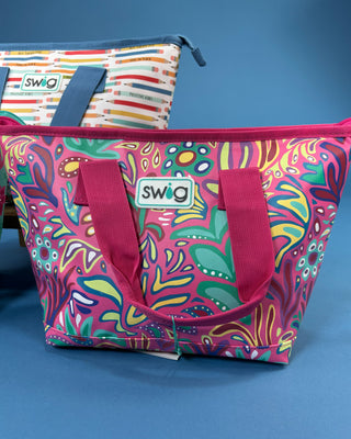 Swig Lunchi insulated lunch bag in multiple colorful prints with waterproof exterior, zipper closure, carry handles, and food-safe insulated lining.