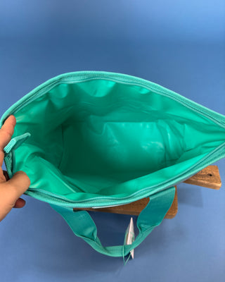 Swig Lunchi insulated lunch bag in multiple colorful prints with waterproof exterior, zipper closure, carry handles, and food-safe insulated lining.
