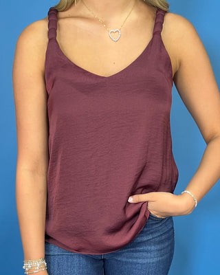 Burgundy sleeveless blouse with a V-neckline, braided shoulder straps, and a relaxed flowy fit.