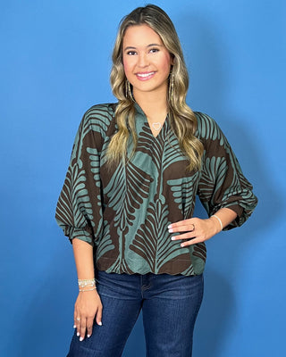 Sage green and brown leaf print blouse with a V-neckline, relaxed fit, and three-quarter balloon sleeves.