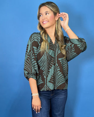 Sage green and brown leaf print blouse with a V-neckline, relaxed fit, and three-quarter balloon sleeves.